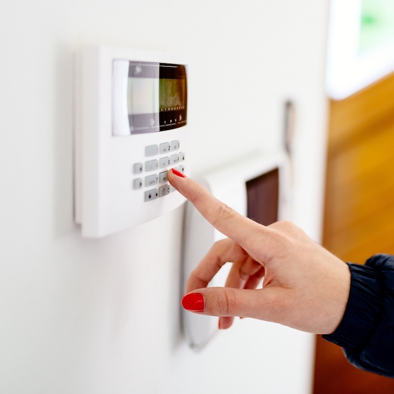 Woman with red nails inputting code into alarm system