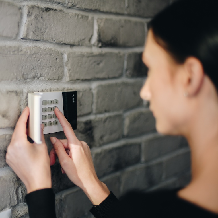 Woman arming an alarm system in her Perth home