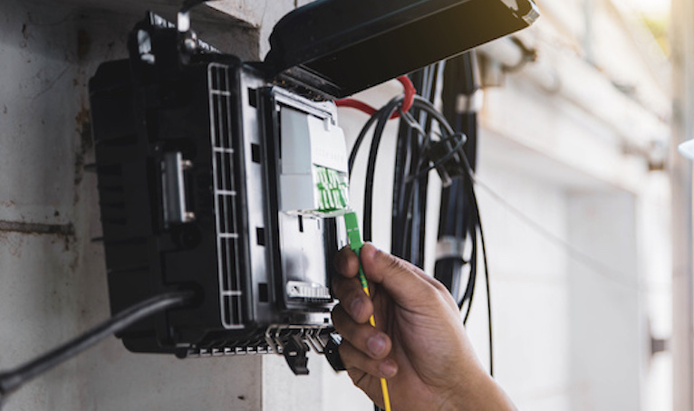 Male installer installing fibre to the premises data cabling in a Perth home