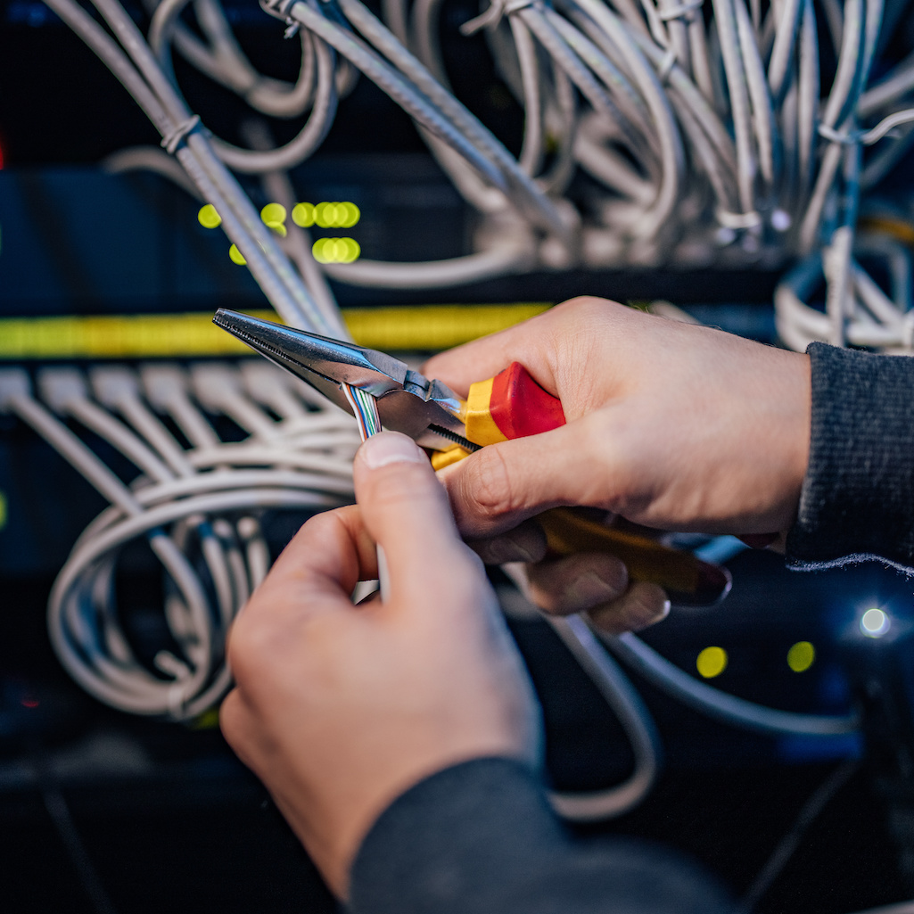 Data cabling being stripped with pliers